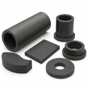 Grainy black-grey Nylatron tube, flanged bushes, a plate, a washer and a curved segment on white
