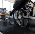 Four black ribbed pedal pads with embossed logo, studio grey background