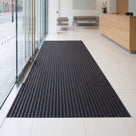 Custom size ribbed PVC entrance mat recessed into a mat well inside the glass doors of an office reception