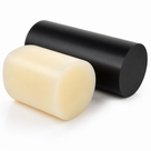 Large ivory nylon billet in front of a matt black billet, both short heavy cylinders on white