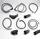 Flat lay of several coiled black rubber E-Type door and window seals on stands