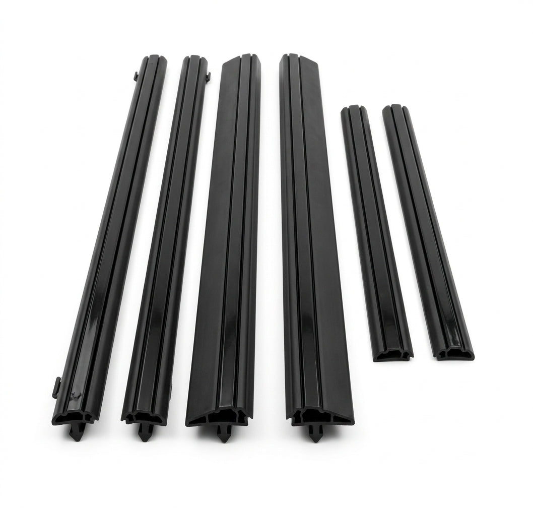 Six black door moulding pieces of varying lengths laid out, white background