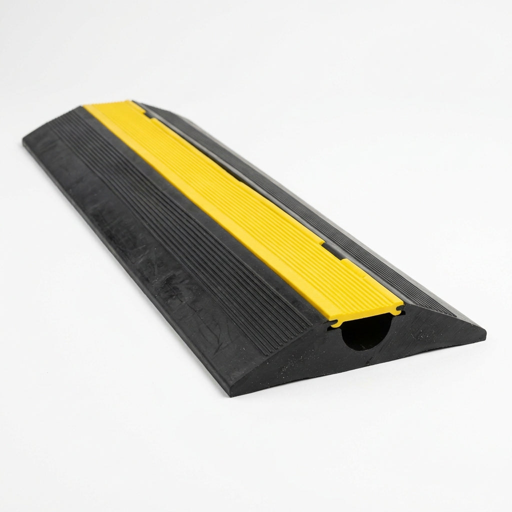 Single channel black rubber cable cover with yellow top strip, sloped edges, cut end shown