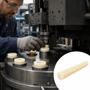 Machinist pressing cream nylon bushes into a steel rotary table, round inset of a cream rod