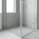 Clear vertical seal down the edge of a frameless glass shower door, water-spotted glass and grey tiles behind