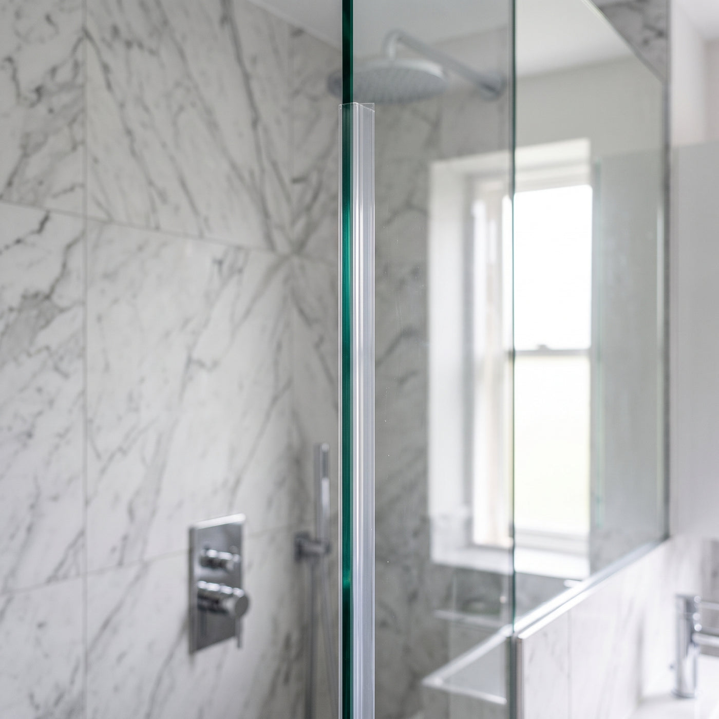 Clear fin seal fitted vertically on the upright edge of a thick 10-12mm glass shower screen