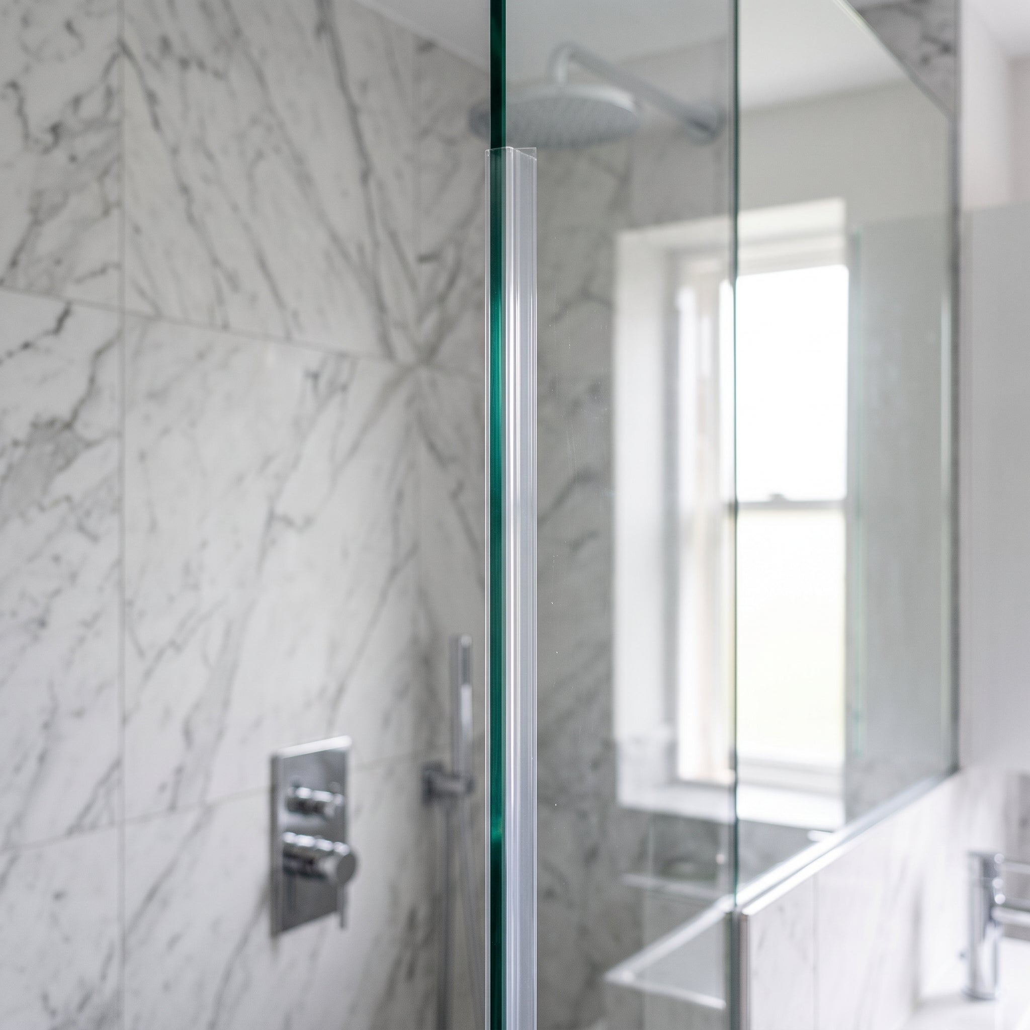 Clear fin seal fitted vertically on the upright edge of a thick 10-12mm glass shower screen