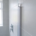 Clear seal fitted down the upright edge of a glass shower screen against a grey tiled wall
