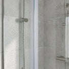Soft-focus view of a pale seal down the join of two misted glass panels, grey tiles blurred behind