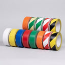 Nine rolls of floor marking tape on a neutral background in white, yellow, blue, red, green, orange and three diagonal stripe patterns