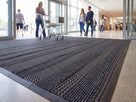 Holly green open-grid entrance matting at a school or leisure centre entrance