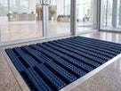 Oxford blue open-grid entrance matting in a corporate building lobby matwell