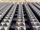 Close-up of the diamond-cut studded bars and open channels holding grit below the walking surface