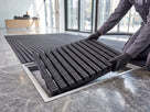 Entrance matting module being lowered into a recessed aluminium matwell frame in a lobby floor