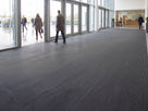 Open-grid entrance matting laid wall to wall across a busy commercial building entrance