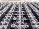 Macro view of rainwater draining through the open channels of Frontrunner Entry matting while the diamond-cut tread stays clear of standing water