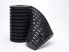 Roll of black Frontrunner Entry open-grid PVC entrance matting partly unrolled, showing the diamond-cut studded bars and open drainage channels