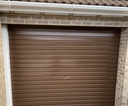 Brown gloss paint freshly applied to an up-and-over garage door on a UK house