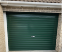 Dark green gloss paint freshly applied to an up-and-over garage door on a UK house