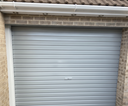 Light grey gloss paint freshly applied to an up-and-over garage door on a UK house