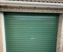 Mid green gloss paint freshly applied to an up-and-over garage door on a UK house
