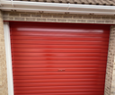 Post office red gloss paint freshly applied to an up-and-over garage door on a UK house