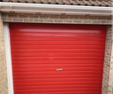 Red gloss paint freshly applied to an up-and-over garage door on a UK house