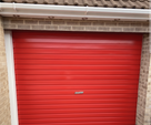 Red gloss paint freshly applied to an up-and-over garage door on a UK house