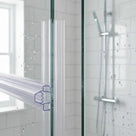 Clear twin-channel seal down a glass panel edge, profile outlined, bridging across to the next panel
