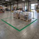 Green floor marking tape outlining a dispatch area with two wrapped pallets beside a loading door