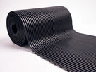 Roll of black 10mm open-rib anti-fatigue matting partially unrolled on a white background