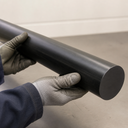 Black HDPE rod held by gloved hands, close-up of the cut end