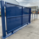 Blue gloss machinery enamel paint applied to a steel factory gate in a UK industrial yard