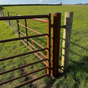 Brown gloss machinery enamel paint applied to a farm gate and fence panel in the UK