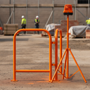 Orange gloss machinery enamel paint applied to a safety barrier frame on a UK construction site