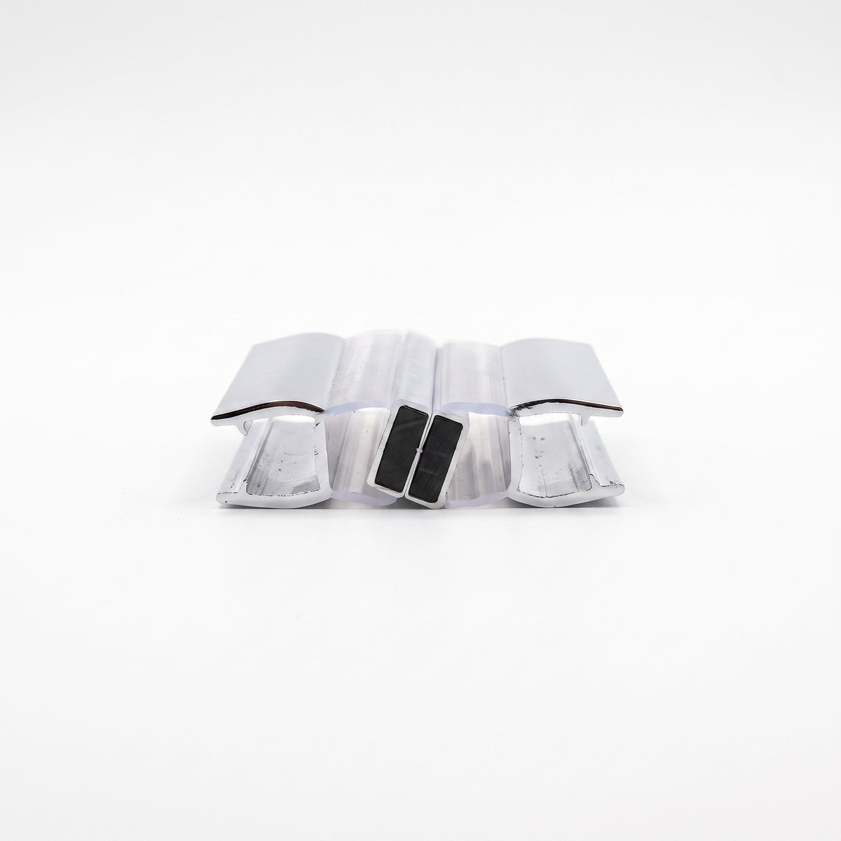 Two chrome-faced seal offcuts end-on on white, black magnets touching at the centre, channels facing out