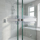 Two clear seals with black magnet strips meeting where wet glass shower doors close, grey tiles behind