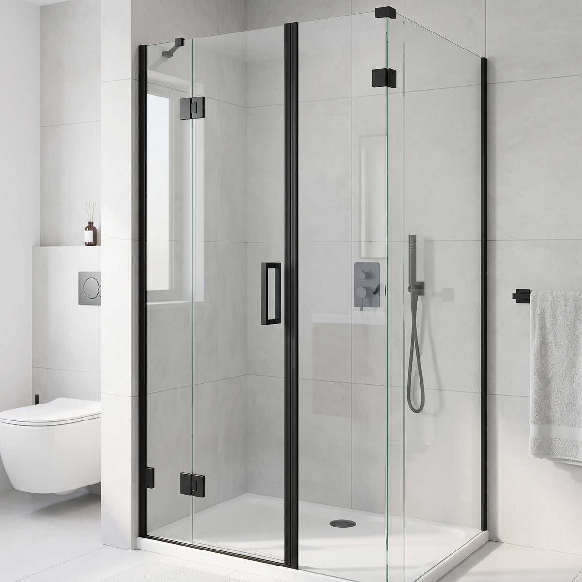 Frameless shower enclosure with black hinges in a grey-tiled bathroom, wall valve and towel rail beside