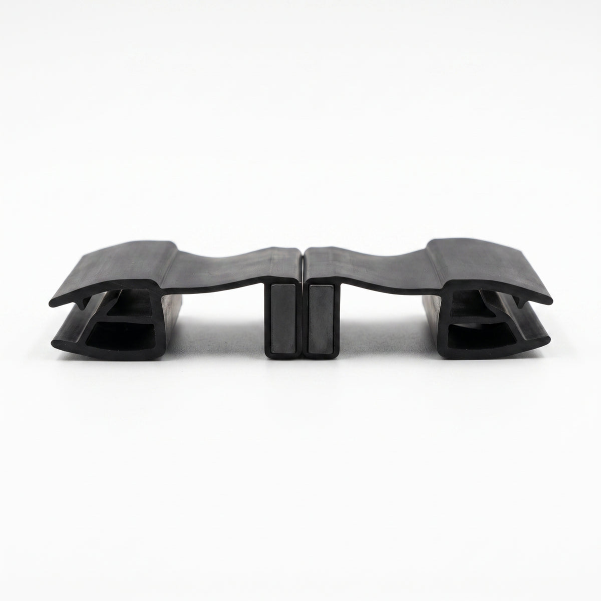 Two black seal offcuts lying flat on white, joined magnet to magnet with a glass channel at each end