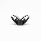 Two black seal profiles opened into a V on white, pale flexible webs above two magnet blocks touching