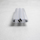 Clear seal pair with chrome-edged channels lying end-on on pale grey, two black magnets meeting centrally