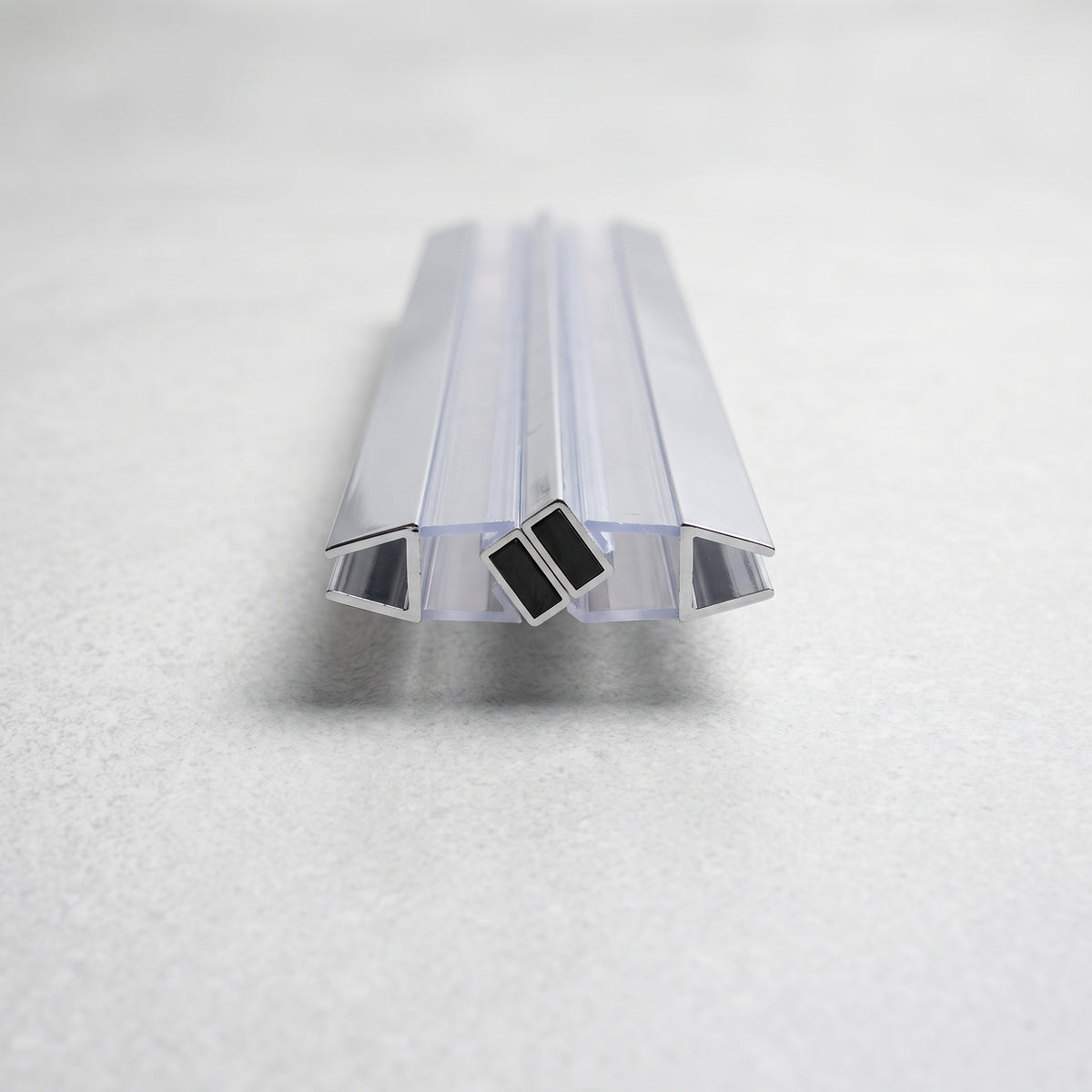 Clear seal pair with chrome-edged channels lying end-on on pale grey, two black magnets meeting centrally