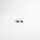 Two small white seal offcuts stood end-on on white, dark magnet faces meeting at their lower ends