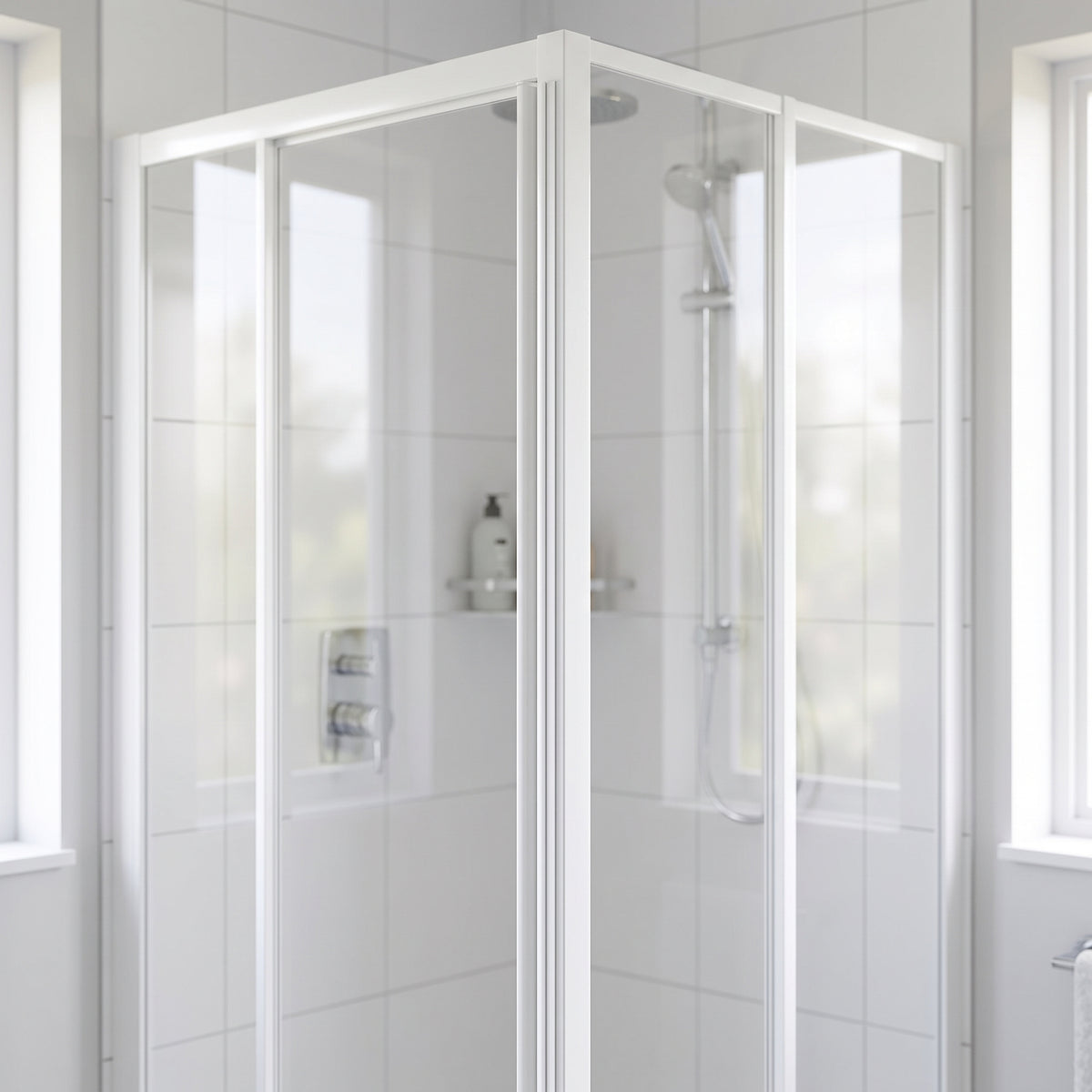 White-framed corner shower enclosure with the two door panels closed on the upright, white tiles and windows