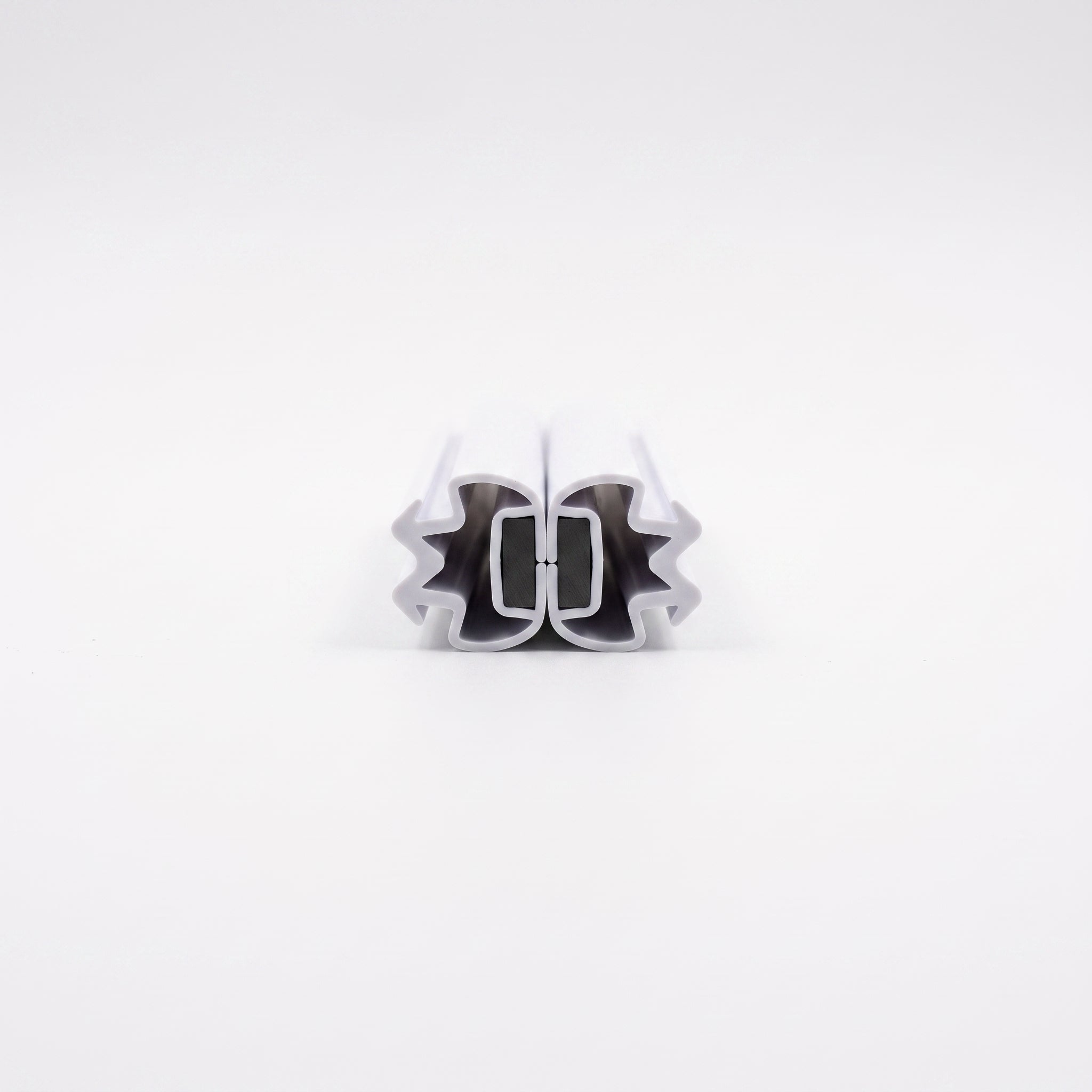 MAG009 white magnetic channel seal pair snapped shut - M-shaped crowns outward, magnets touching face to face