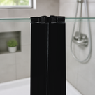 Black inline magnetic seals joining two glass shower panels, chrome valve and hose on grey tiles behind