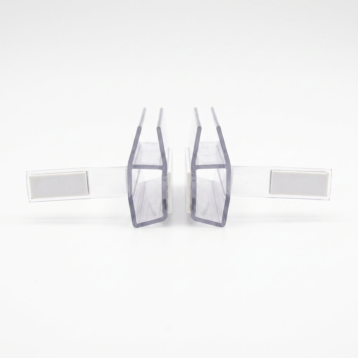Two clear magnetic seal profiles facing each other on white, wide white magnet blocks on flexible arms