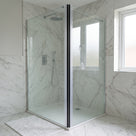 Marble-tiled shower enclosure, a dark magnetic closing line running the full height of the door edge