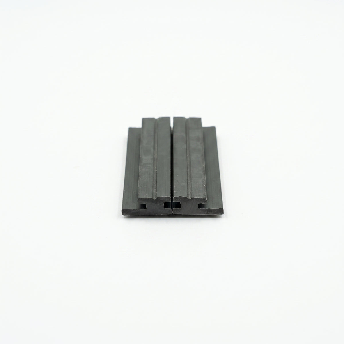 Two black magnetic seal strips butted together on white, ribbed faces upward, cut ends towards the camera