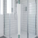 White magnetic seal line running full height where two glass shower doors meet, metro tiles behind
